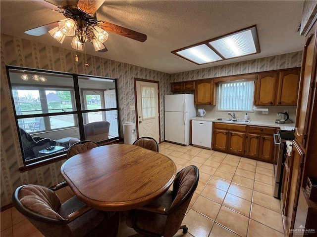 dining room with light tile patterned floors, ceiling fan, a textured ceiling, and wallpapered walls