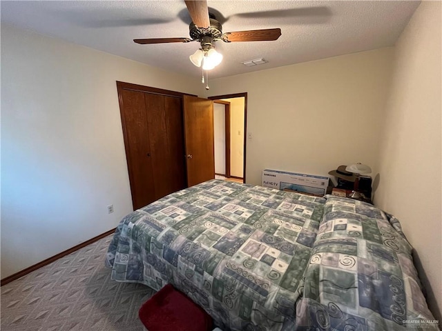 bedroom with carpet floors, a closet, visible vents, a textured ceiling, and baseboards