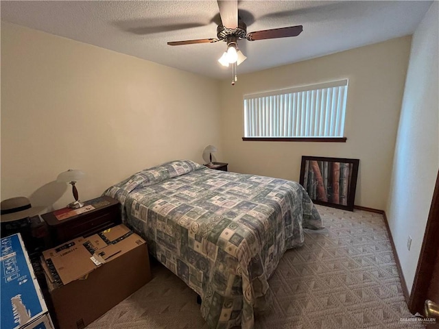 bedroom featuring ceiling fan, a textured ceiling, carpet, and baseboards