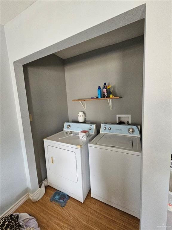 clothes washing area with wood-type flooring and independent washer and dryer