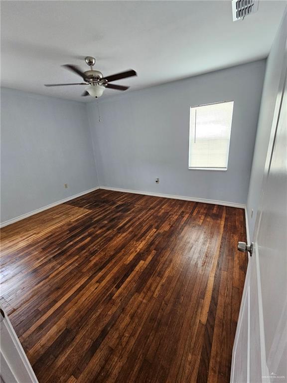 unfurnished room featuring ceiling fan and dark hardwood / wood-style flooring