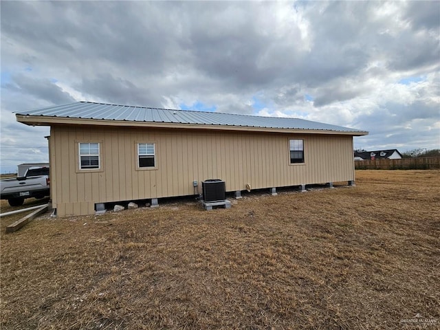 view of side of home featuring a yard and central AC