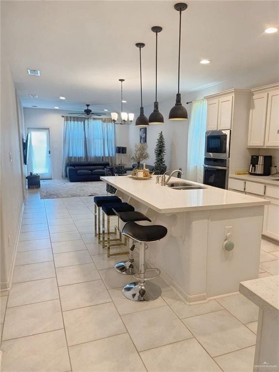 8507 N 33rd Ln N, Mcallen, TX 78504 - kitchen featuring stainless steel appliances, a sink, a ceiling fan, light tile patterned floors, and light countertops