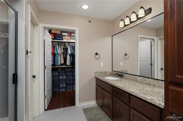 1200 E Pineridge Ave Unit 1, Mcallen, TX 78503 - bathroom with vanity, tile patterned floors, a spacious closet, and baseboards