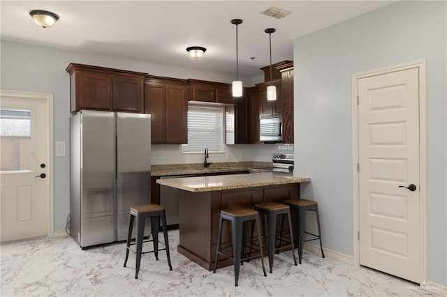 1200 E Pineridge Ave Unit 1, Mcallen, TX 78503 - kitchen featuring appliances with stainless steel finishes, light marble finish flooring, a breakfast bar, and dark brown cabinets