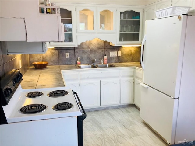 kitchen with tasteful backsplash, sink, white cabinets, white fridge, and electric range