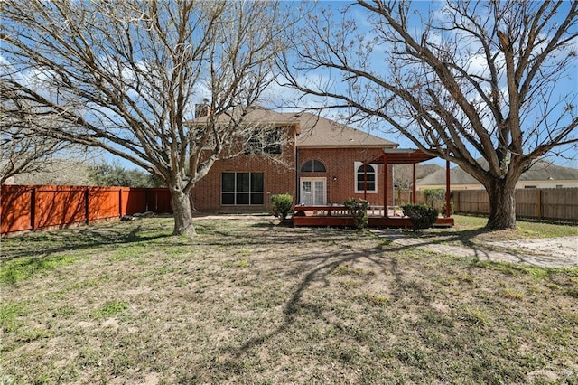 back of property with a lawn and a wooden deck