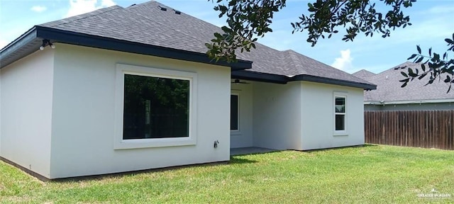 rear view of house featuring a lawn