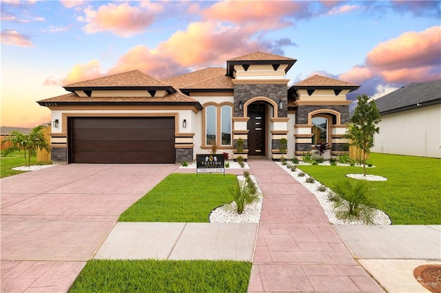 view of front of property with a garage and a yard