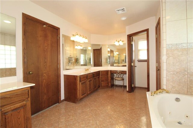 bathroom featuring a washtub, vanity, and tile patterned flooring