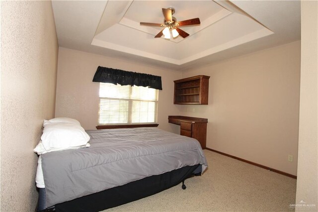 bedroom featuring a raised ceiling, ceiling fan, and carpet floors