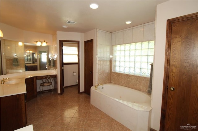 bathroom with a bath, vanity, tile patterned floors, and a healthy amount of sunlight