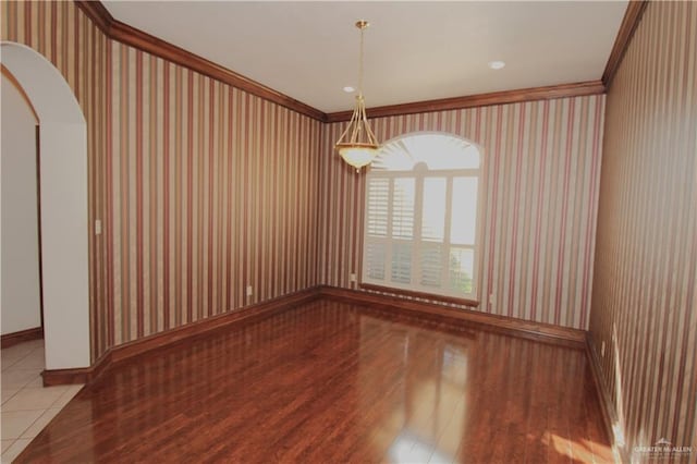 spare room featuring light hardwood / wood-style flooring and crown molding