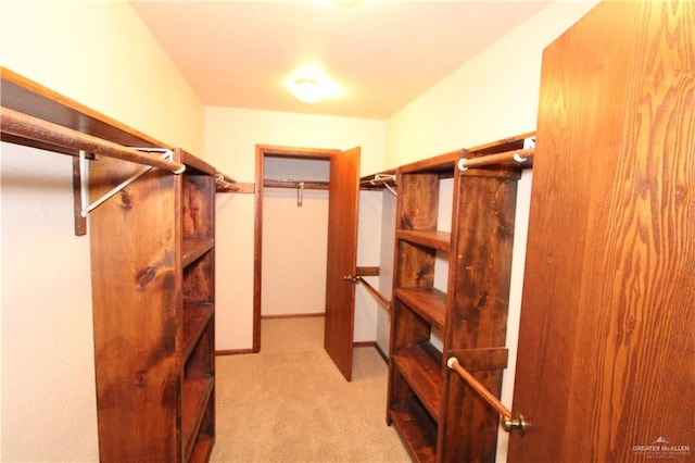 spacious closet featuring light colored carpet