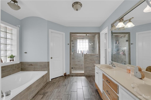 bathroom with vanity and shower with separate bathtub