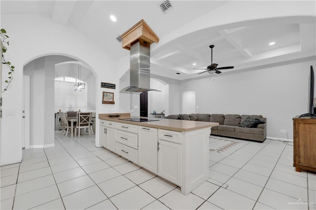 kitchen with island exhaust hood, light tile patterned floors, white cabinets, and black electric cooktop