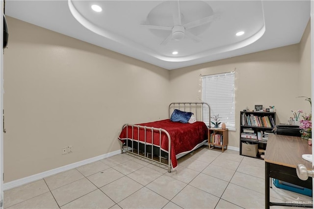 tiled bedroom featuring ceiling fan and a raised ceiling