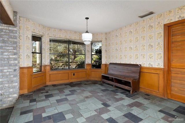 unfurnished dining area featuring a textured ceiling