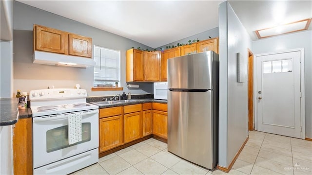 kitchen featuring white appliances, under cabinet range hood, a sink, and light tile patterned flooring