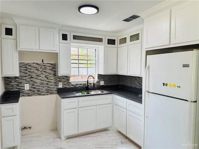 314 W Lincoln Ave, Harlingen, TX 78550 - kitchen featuring freestanding refrigerator, light marble finish flooring, and dark countertops