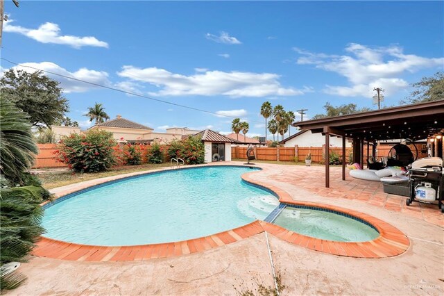 view of swimming pool with a patio area and an in ground hot tub