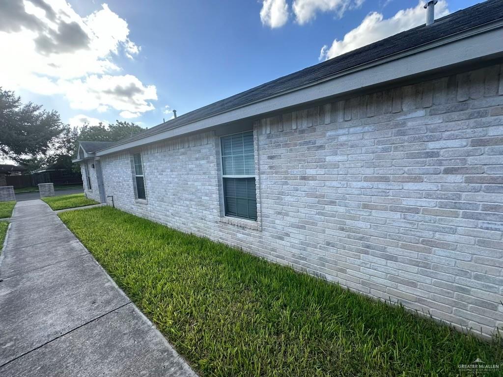 view of side of home with a lawn