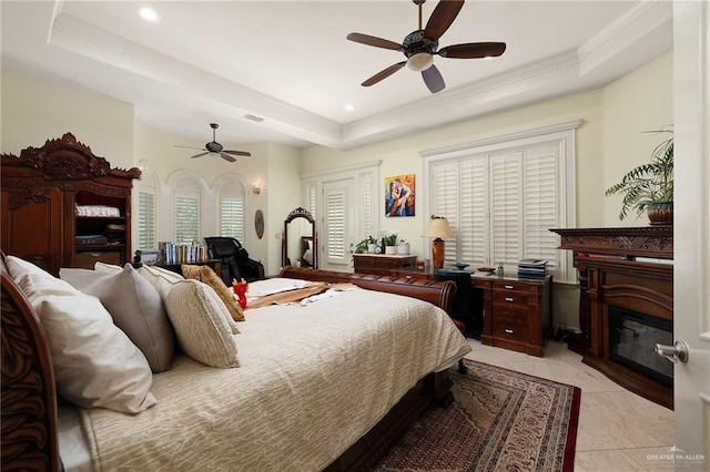 16408 Garrett Rd, Harlingen, TX 78552 - bedroom with a tray ceiling, a glass covered fireplace, a ceiling fan, recessed lighting, and crown molding