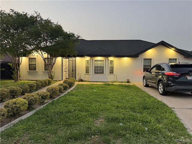 2110 Tiffany Dr, Mission, TX 78574 - view of front of house with a front yard, stucco siding, and roof with shingles