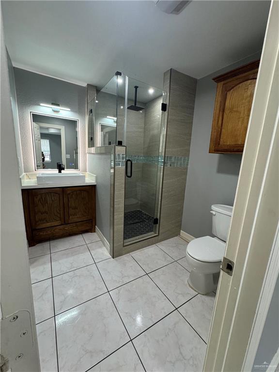 2110 Tiffany Dr, Mission, TX 78574 - full bath with vanity, toilet, a shower stall, and baseboards