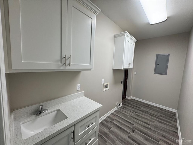 laundry room featuring sink, dark hardwood / wood-style flooring, cabinets, electric panel, and hookup for a washing machine