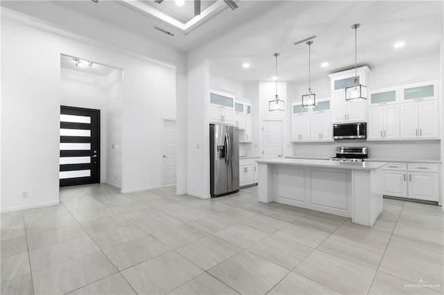 kitchen with appliances with stainless steel finishes, white cabinets, and a kitchen island