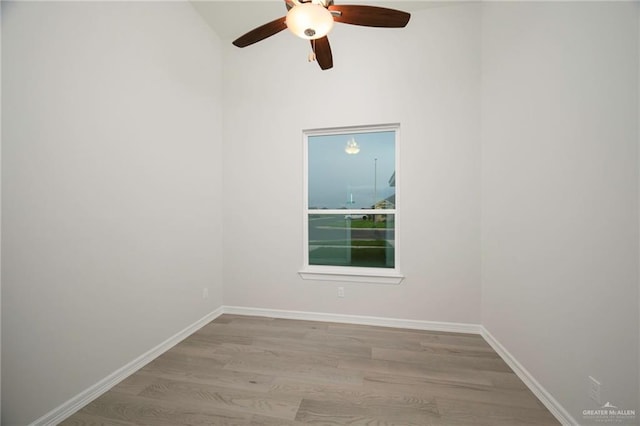 spare room with ceiling fan, light hardwood / wood-style floors, and vaulted ceiling