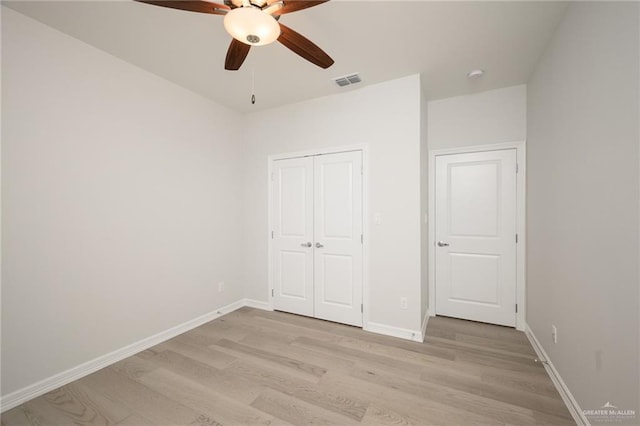 unfurnished bedroom featuring ceiling fan, light hardwood / wood-style floors, and a closet