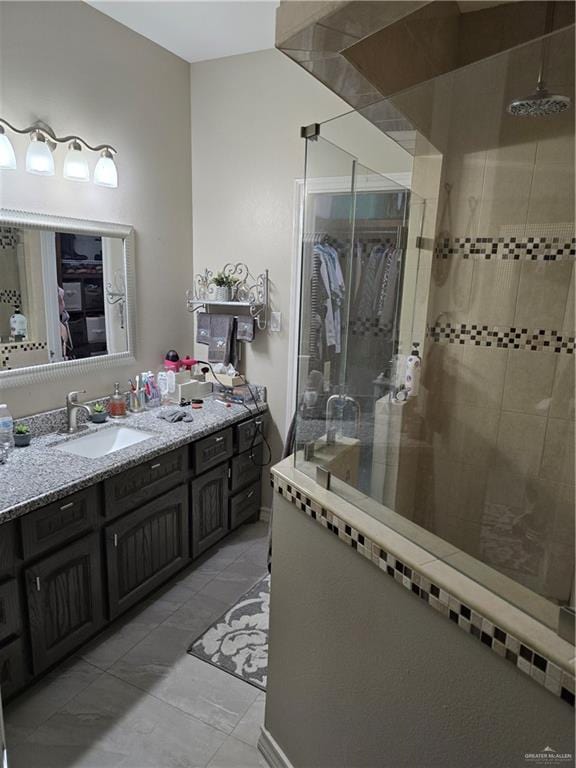 bathroom with tiled shower and vanity