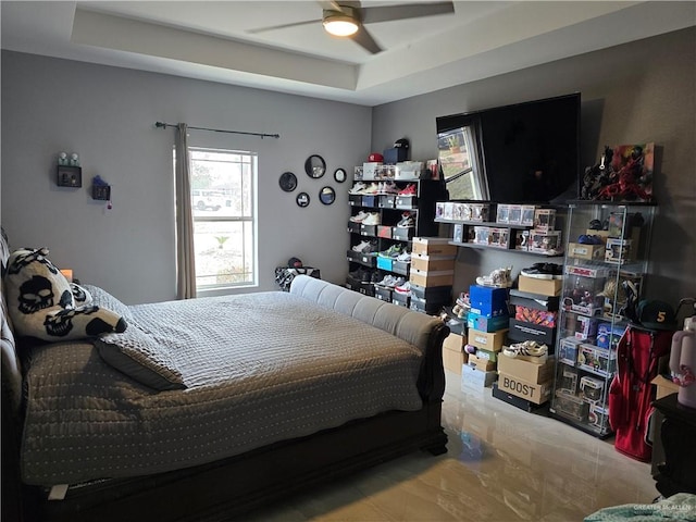 bedroom with ceiling fan and a raised ceiling