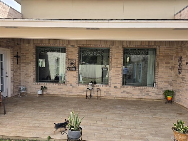 view of exterior entry with a patio