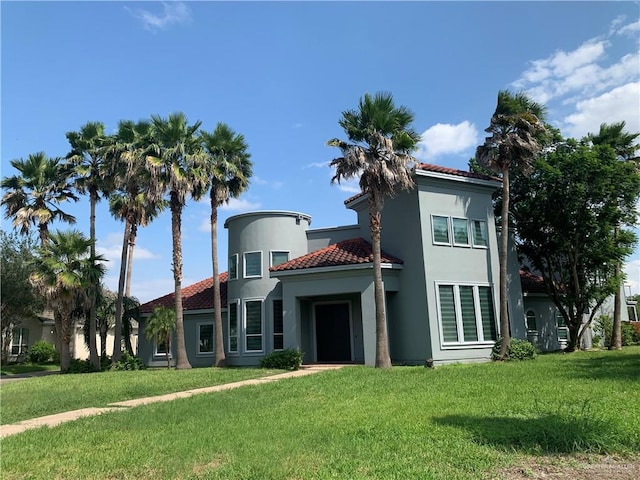 mediterranean / spanish home with a front lawn