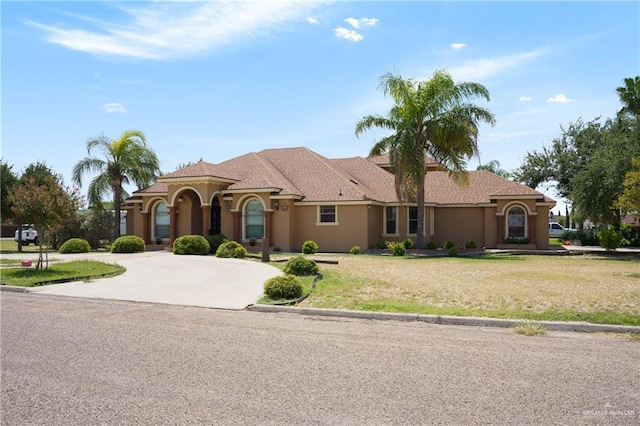 mediterranean / spanish-style house with a front yard