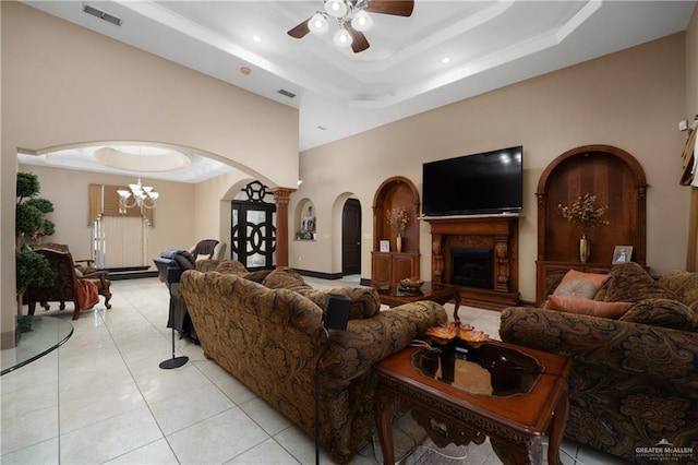 living room featuring a raised ceiling, a towering ceiling, light tile patterned floors, and ceiling fan with notable chandelier