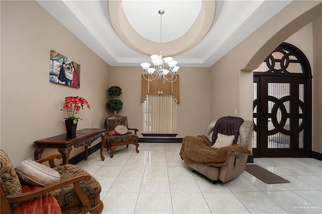 living area featuring light tile patterned floors, a raised ceiling, and a notable chandelier