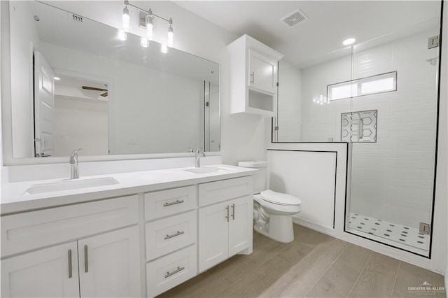 bathroom featuring vanity, hardwood / wood-style floors, an enclosed shower, and toilet