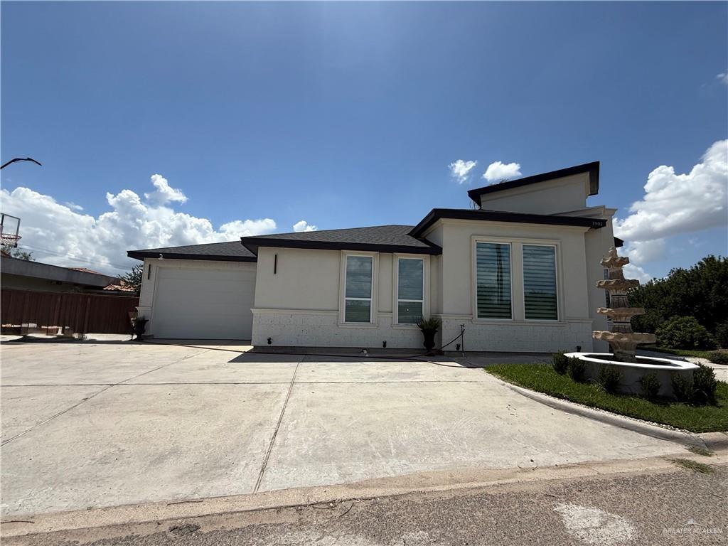 1901 Lake Point Dr, Mission, TX 78572 - view of front facade with an attached garage, driveway, and stucco siding
