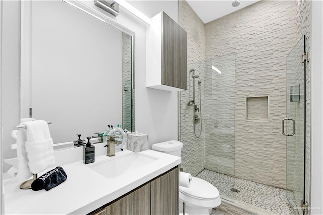 bathroom featuring an enclosed shower, vanity, and toilet