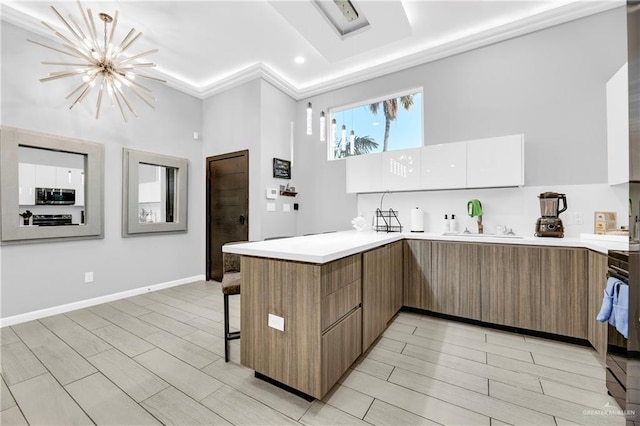 kitchen with a chandelier, appliances with stainless steel finishes, light wood-type flooring, and white cabinetry