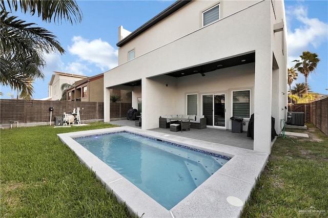 rear view of property with a lawn, an outdoor living space, a fenced in pool, central AC unit, and a patio