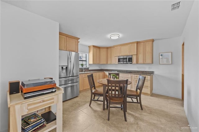 2005 E Bogey Dr, Mission, TX 78572 - kitchen featuring stainless steel appliances, light brown cabinetry, a sink, and dark countertops