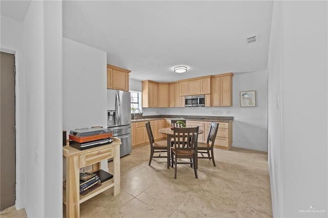 2005 E Bogey Dr, Mission, TX 78572 - kitchen featuring appliances with stainless steel finishes, light brown cabinetry, a sink, and dark countertops