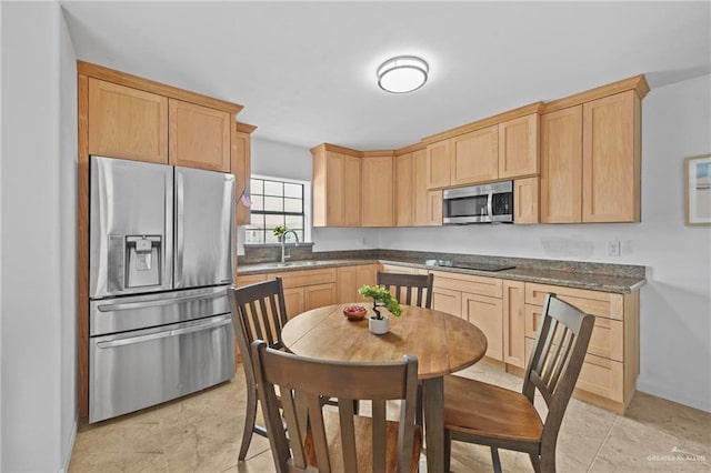 2005 E Bogey Dr, Mission, TX 78572 - kitchen with appliances with stainless steel finishes, light brown cabinetry, a sink, dark countertops, and baseboards
