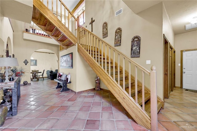 2724 Wildwood Dr, Weslaco, TX 78596 - stairway featuring arched walkways, a towering ceiling, and tile patterned floors