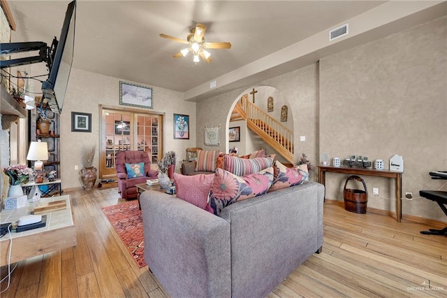 2724 Wildwood Dr, Weslaco, TX 78596 - living room featuring a ceiling fan, wood-type flooring, arched walkways, baseboards, and stairs